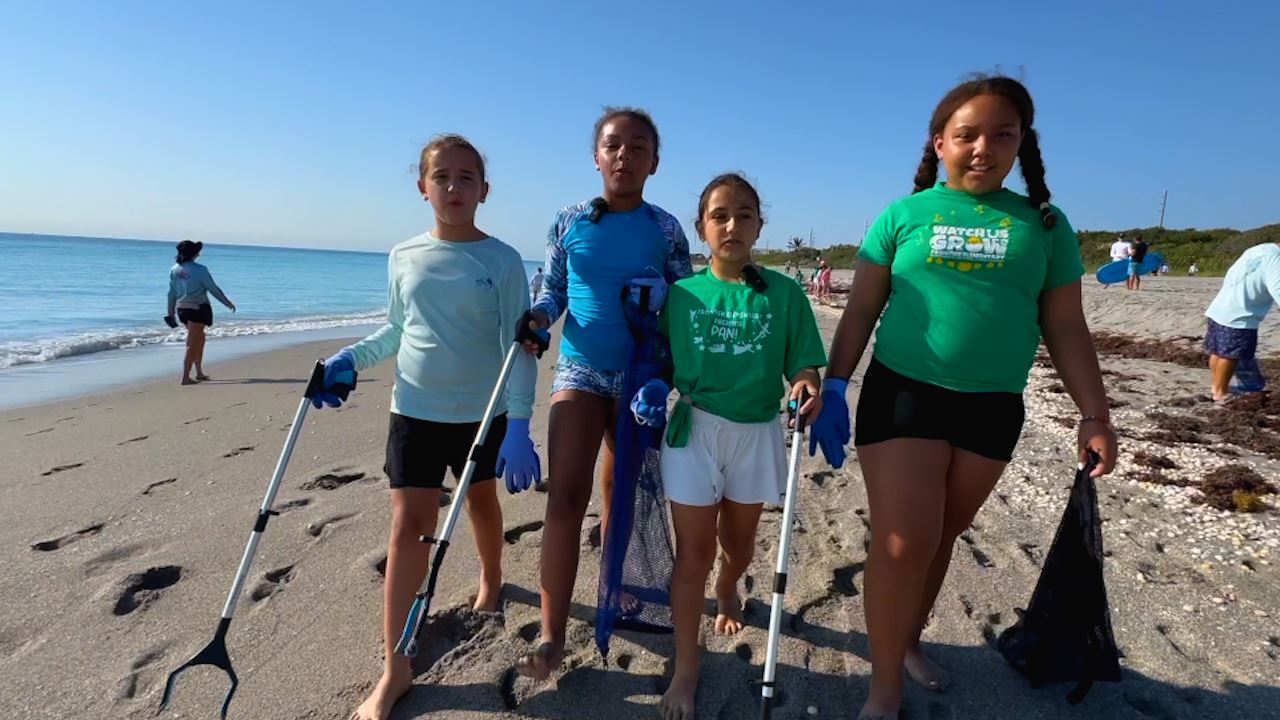  Elementary students out picking up trash at a beach